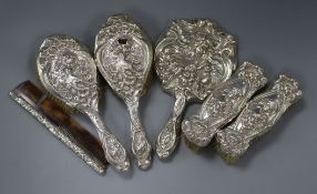 An Edwardian five piece embossed silver mounted dressing table set by Levi & Salaman and a similar