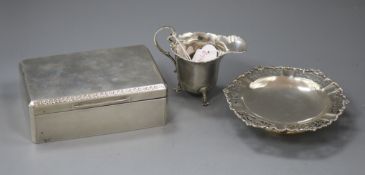 A silver helmet shaped cream jug, a silver mounted cigarette box and a silver bon-bon dish.