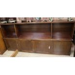 A mahogany low bookcase, fitted adjustable shelving over cupboards W.241cm