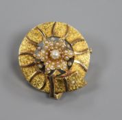 A yellow metal and seed pearl set circular 'belt and flower head' brooch, 25mm.