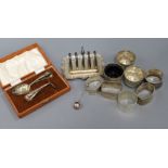 A cased silver spoon and pusher, a silver toast rack, three silver salts, five silver napkin rings