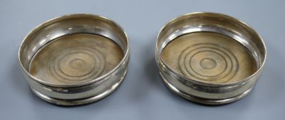 A pair of 1960's silver wine coasters with turned wooden bases, London, 1968/9, 13.2cm.