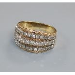A yellow metal and three row diamond dress ring, size L.