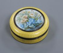 An early 20th century silver and enamel circular box and cover with central painted floral panel,