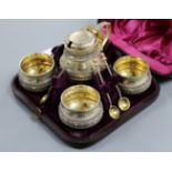 A cased Victorian parcel gilt silver five piece condiment set with five spoons, by George Fox,