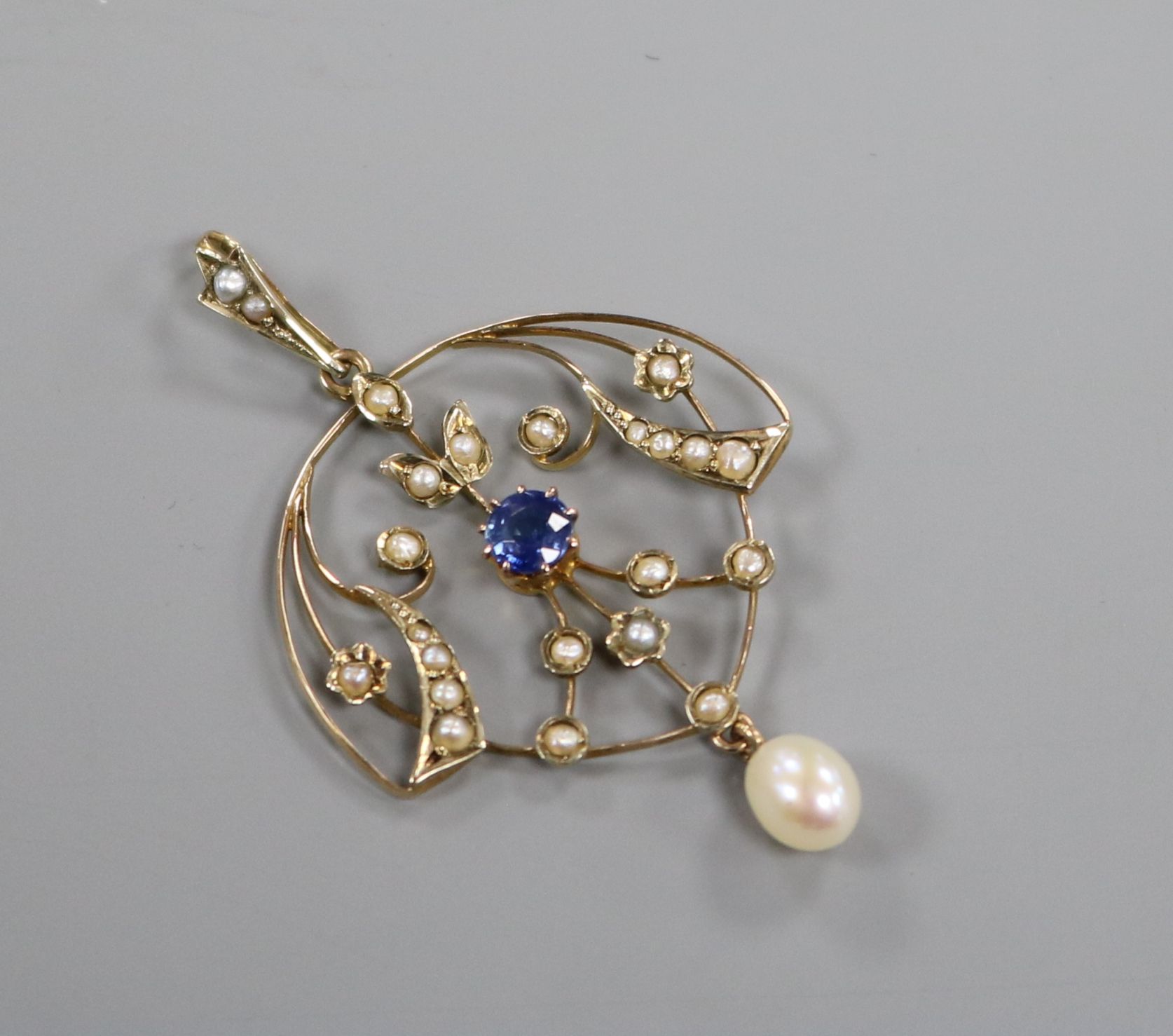 An Edwardian 9ct gold, sapphire and seed pearl set drop pendant, 36mm.