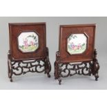 A pair of Chinese carved and pierced hardwood table screens, 19th century, inset with octagonal