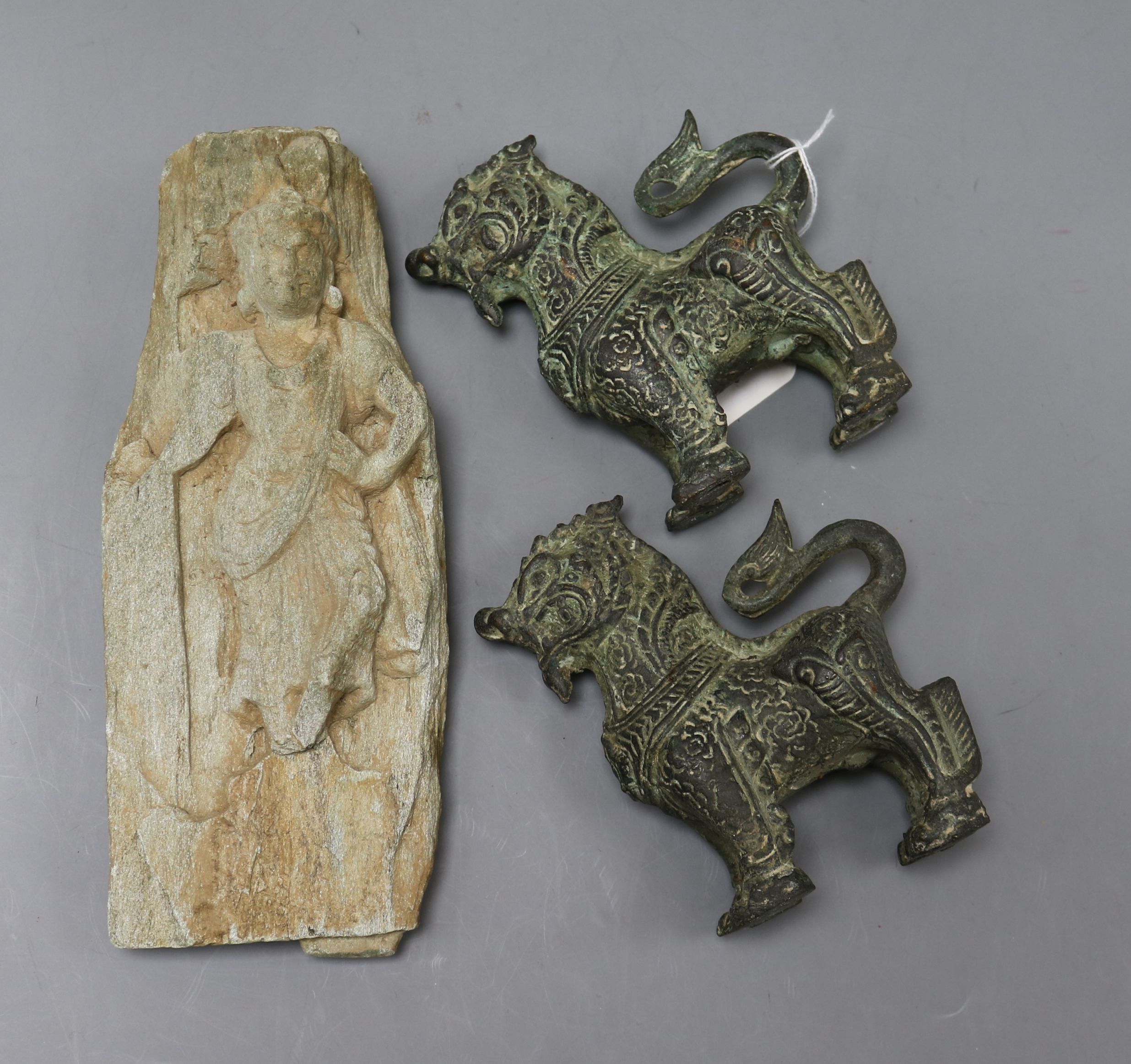 A Chinese stone fragment carved with a buddha in relief, possibly Jin Dynasty and a pair of small