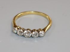 An 18ct gold and graduated five stone diamond half hoop ring, size M.