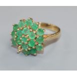 A modern 9ct gold and emerald set cluster dress ring(one stone missing), size N.