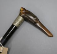 A ebonised walking cane with engraved white metal collar and carved horn greyhound handle