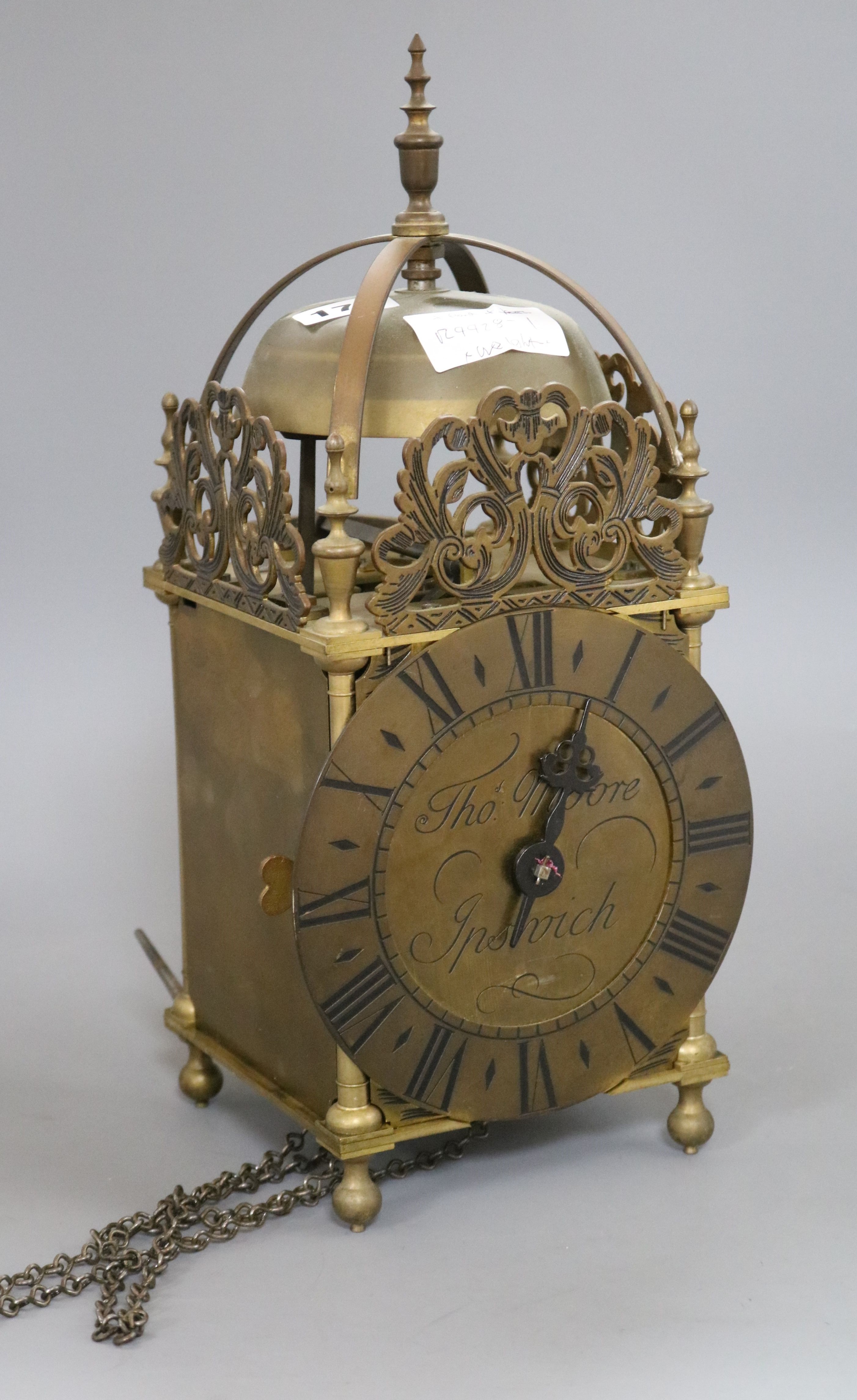 An early 20th century brass lantern clock, by Thos. Moore, Ipswich, with weight and pendulum. height