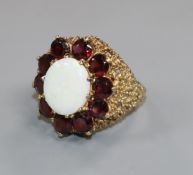 A modern 9ct gold, white opal and garnet? set oval dress ring, size L.