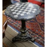 A Victorian papier mache games table, painted and gilded and inlaid with mother of pearl, raised