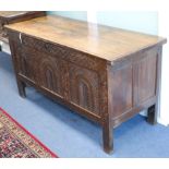 A 17th century carved oak panelled chest with planked top W.148cm