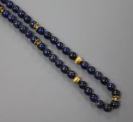 A lapis lazuli and yellow metal spacer bead necklace, with 750 flower head clasp, 47cm.