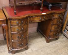 A reproduction Georgian style shape fronted mahogany twin pedestal desk, the top inset red