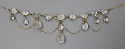 A yellow metal and moonstone set spectacle drop necklace (one stone missing), 42cm.