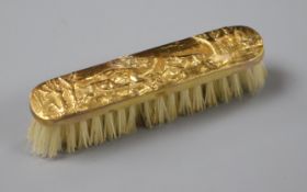 An early 20th century repousse 9ct gold mounted miniature brush decorated with hunting scene, in