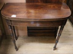 A Regency inlaid mahogany D shaped folding card table, on ring turned supports W.90cm