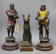 A pair of coloured spelter figures of knights and a composition figure of a cat