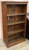 A Victorian walnut open fronted bookcase, fitted adjustable shelves and standing on a plinth base,