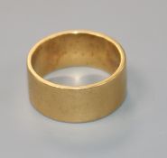 An 18ct yellow gold wide wedding band, size T.