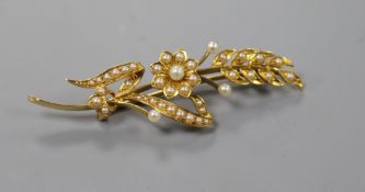 A yellow metal and seed pearl openwork floral and foliate spray brooch, 58mm.
