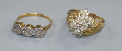 Two yellow metal and diamond set dress rings including illusion set three stone ring.