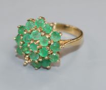 A modern 9ct gold and emerald set cluster dress ring(one stone missing), size N.
