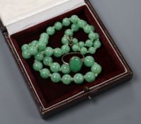 A cabochon jade and 18ct white gold ring and a graduated jade bead necklace.