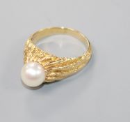 A 14ct textured yellow gold modernist ring set with a single cultured pearl, size P.