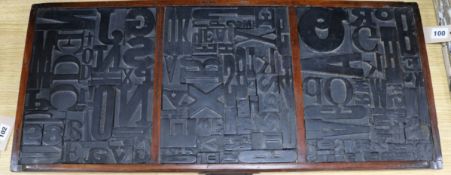 A framed collection of printing blocks 82cm wide x 36cm high