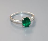 A modern 9ct white gold, synthetic emerald ring with diamond set shoulders, size O.