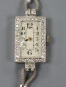 A lady's platinum and diamond set rectangular dial cocktail watch, on a white metal twin strand