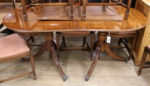 A Regency style inlaid mahogany two pillar dining table, with one spare leaf W.164cm