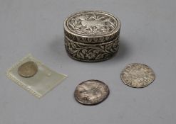 An antique embossed white metal oval pill box and three antique coins.