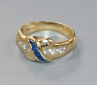 A modern 585 yellow metal and two colour sapphire? ring with 'X' motif, size O.