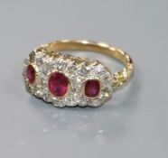 A yellow metal, ruby and diamond triple cluster ring, size O.