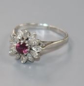 A modern 18ct white gold, ruby and diamond cluster flower head ring, shank a.f. size N.