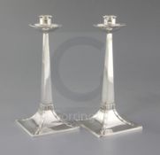 A pair of Edwardian Arts and Crafts silver candlesticks by James Dixon & Sons, with square
