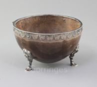 A Victorian silver mounted coconut bowl by William Stocker, with engraved border, on three pad