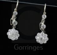 A pair of white gold and diamond flower head cluster drop earrings, each set with eleven round cut