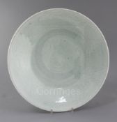 A Chinese celadon glazed dish, 19th century, the centre incised with a flowerhead, the borders