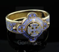 A Victorian gothic style gold and pale blue enamel hinged bangle, with pierced central motif and