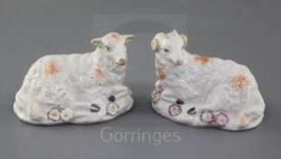 A rare pair of early Derby figures of a ram and a ewe, c.1756, each recumbent on a flower