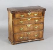 A George I featherbanded walnut bachelor's chest, with folding top and four graduated long