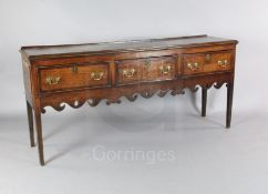 A George III crossbanded oak dresser base, with three drawers and pierced apron, on squared