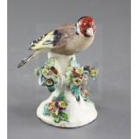 A Derby model of a goldfinch, c.1760-5, perched on a floral encrusted tree branch, patch marks, h.