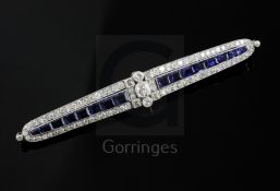 An Art Deco white gold?, sapphire and diamond bar brooch, of tapering form and set with round and